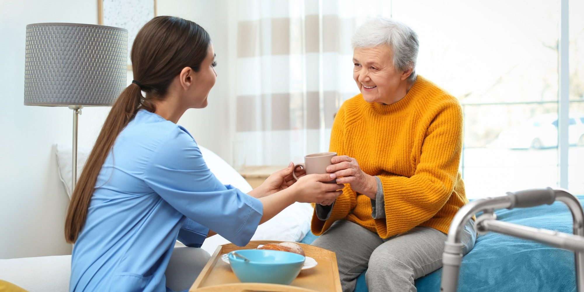 Elderly Wooman enjoying a cup of tea with her carer in her own home | Bristol Domiciliary Carer Providers