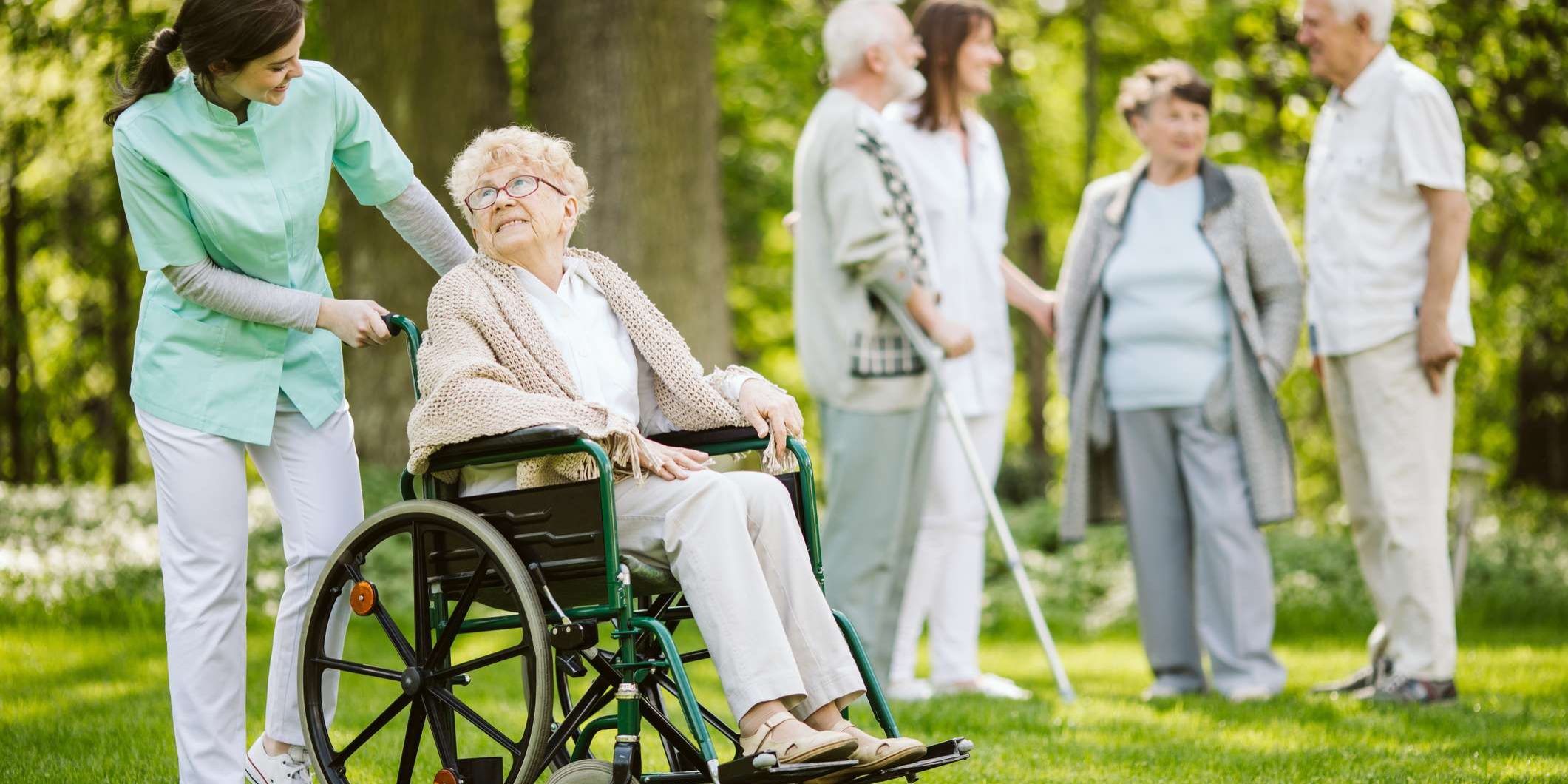 Elderly woman on a wheelchair enjoying the fresh air with the help of her carer | Bristol Home Care Providers