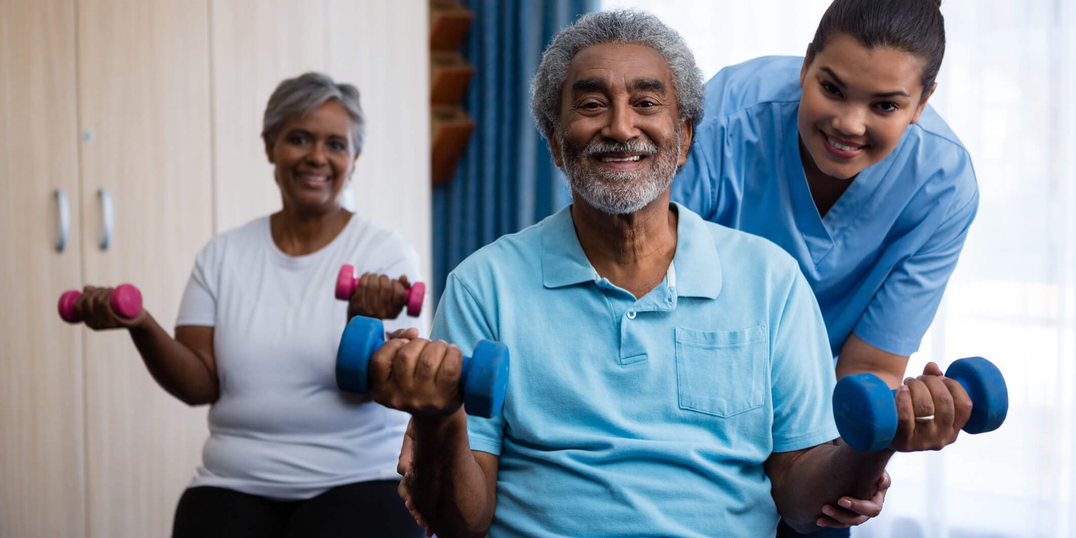 Old Couple exercising with the help of a carer | Bristol Home Care Services