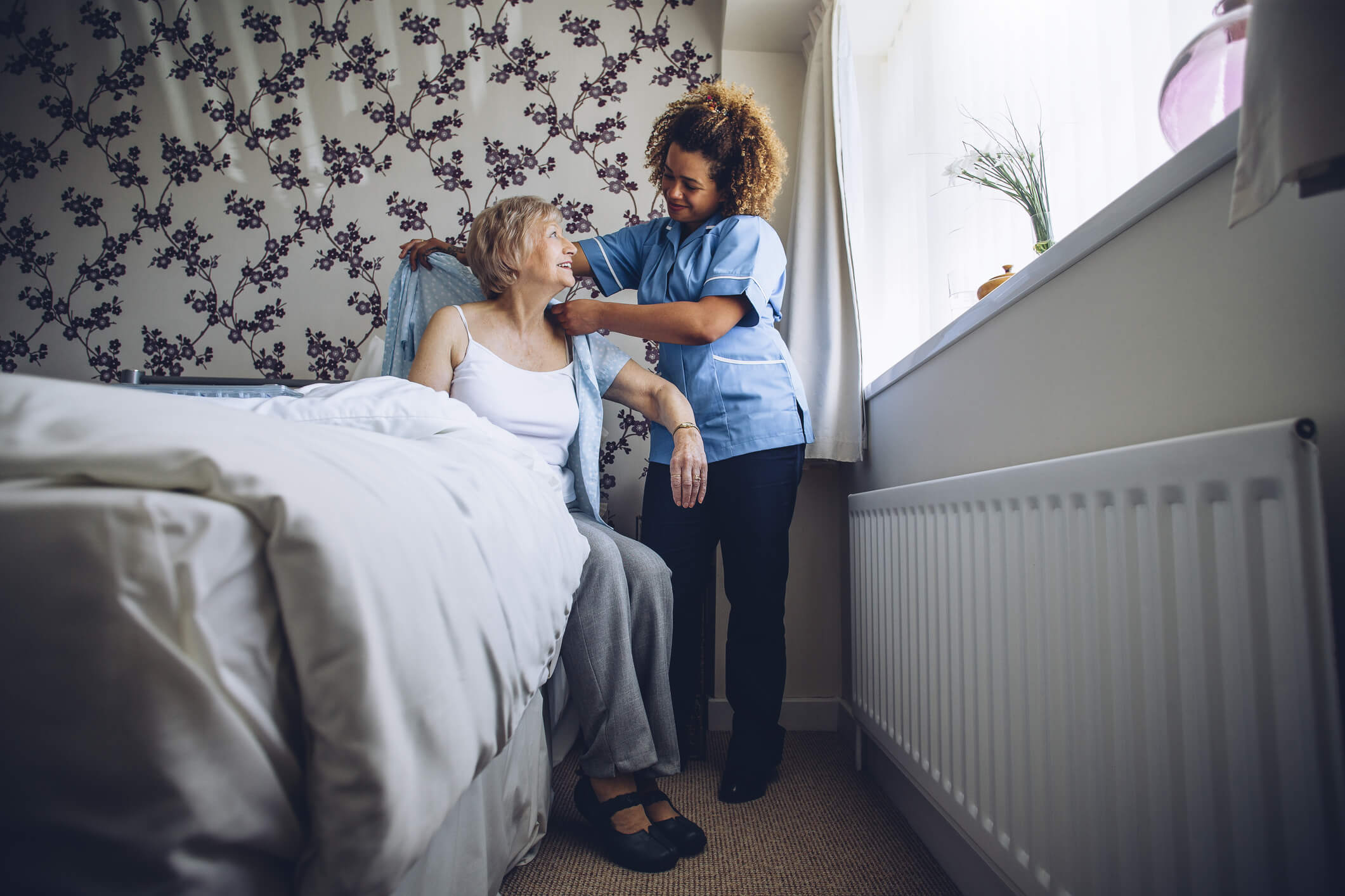 Carer Helping a woman get out of bed | Bristol Care Providers